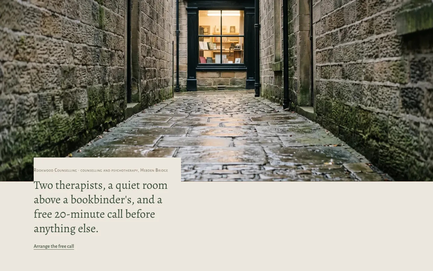 First screen of the fictional Rookwood Counselling example: a wet side street, a lit bookbinder's window, and the line about two therapists and a free 20-minute call.
